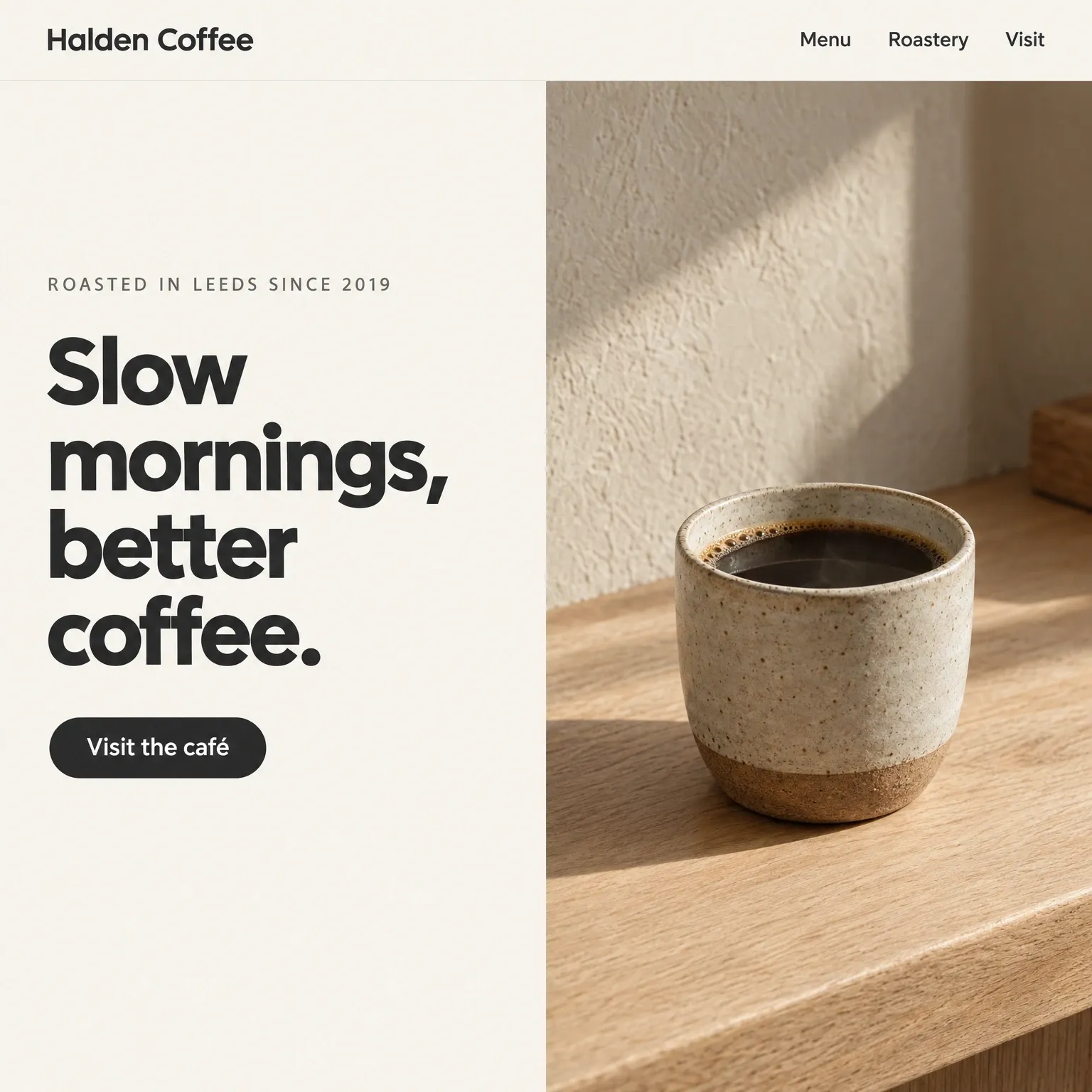 A coffee roastery homepage: warm off-white, a charcoal headline and a photograph of a stoneware cup